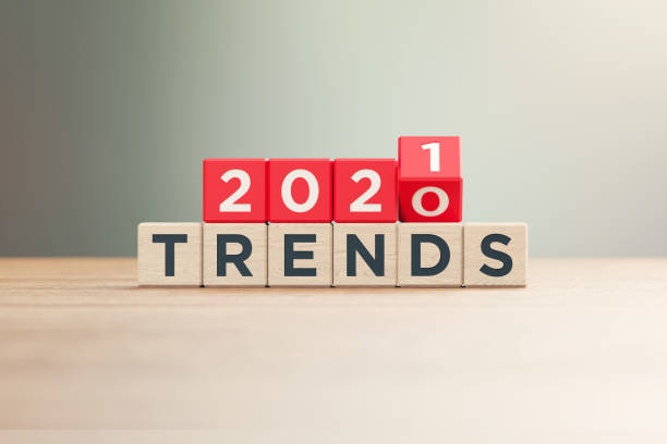 "2020" und "2021 trends" geschrieben rote holzblöcke sitzen auf holzoberfläche vor einem defokussierten hintergrund - zeitmessinstrument grafiken stock-fotos und bilder