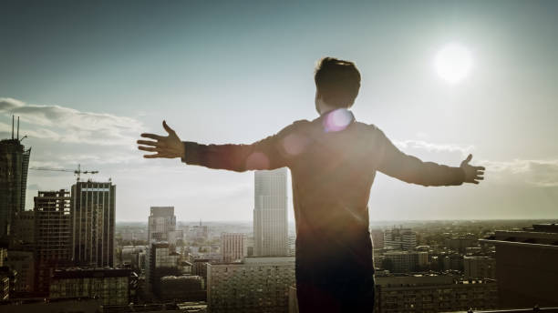 istock Freedom metaphor. Man on the rooftop with open arms 1253506431