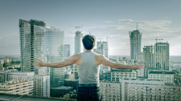 istock Freedom metaphor. Man on the rooftop with open arms 1253506433
