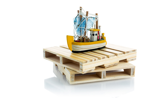 Small fishing boat on wooden pallets. Conceptual image about the fishing industry.