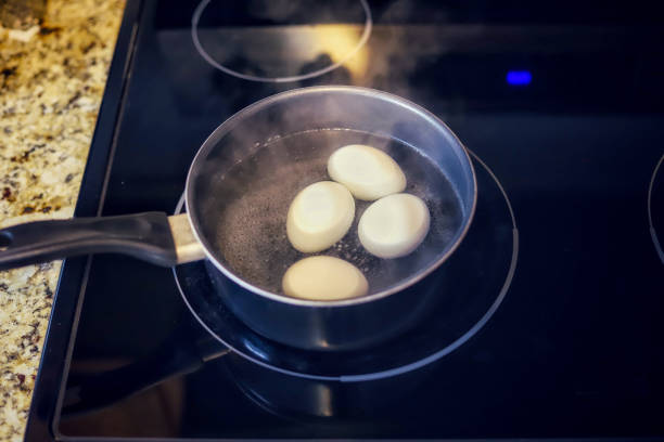 ストーブの上で沸騰する有機卵の鍋 - poached egg ストックフォトと画像
