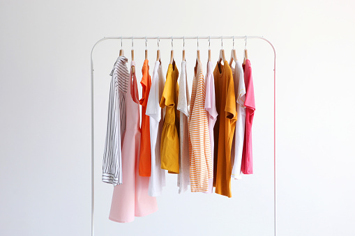 fashionable clothes on a rack in the interior of a bright room