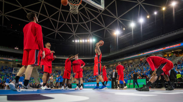 istock Basketball players warming up on court 1253511511