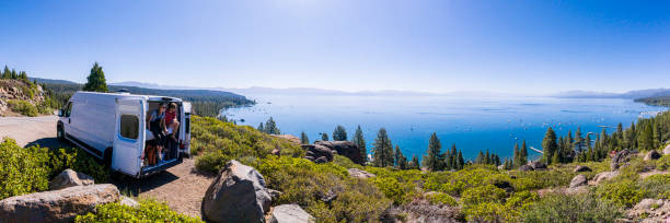 jovem casal parked van em um mirante do lago tahoe - travel trailer - fotografias e filmes do acervo