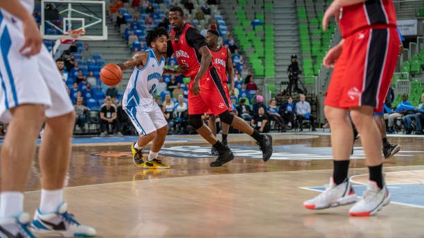 istock Basketball players tackling for ball 1253513152