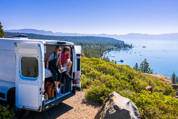 jovem casal parked van em um mirante do lago tahoe - travel trailer - fotografias e filmes do acervo