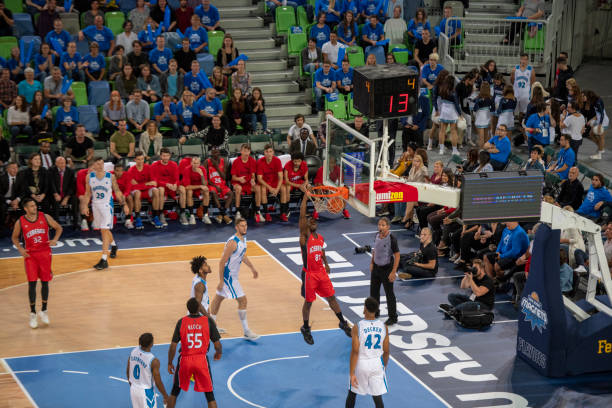 istock Basketball player slam dunking ball 1253513838