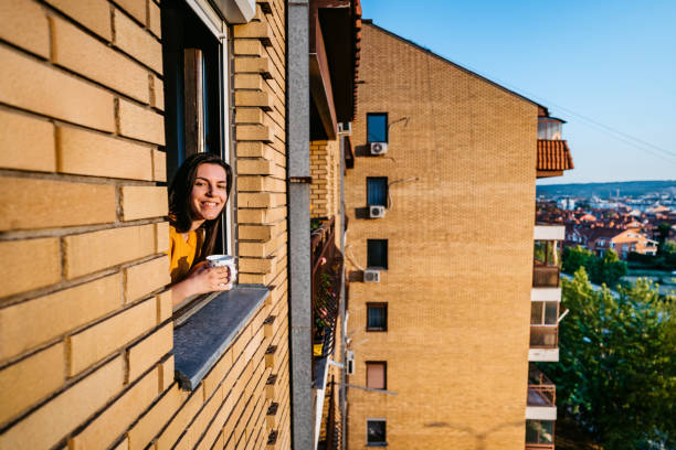 istock Woman drinking coffee at window 1253513963