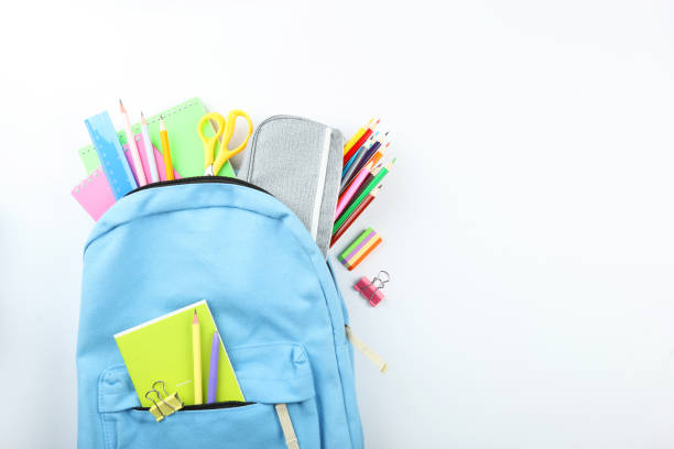 istock school backpack and school stationery on a colored background top view. Concept back to school. 1253514933