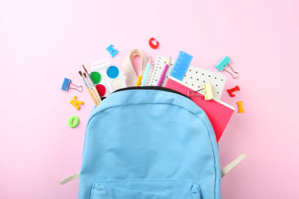 istock school backpack and school stationery on a colored background top view. Concept back to school. 1253515014
