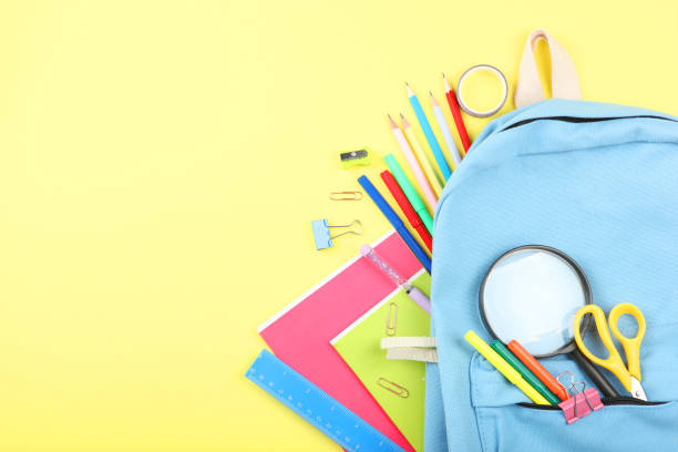 istock school backpack and school stationery on a colored background top view. Concept back to school. 1253515020