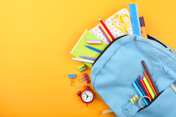istock school backpack and school stationery on a colored background top view. Concept back to school. 1253515053