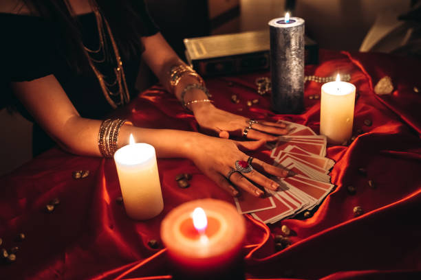 Fortune teller reading tarot Young female fortune teller reading tarot. witch stock pictures, royalty-free photos & images