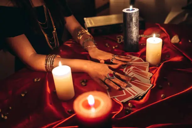Young female fortune teller reading tarot.