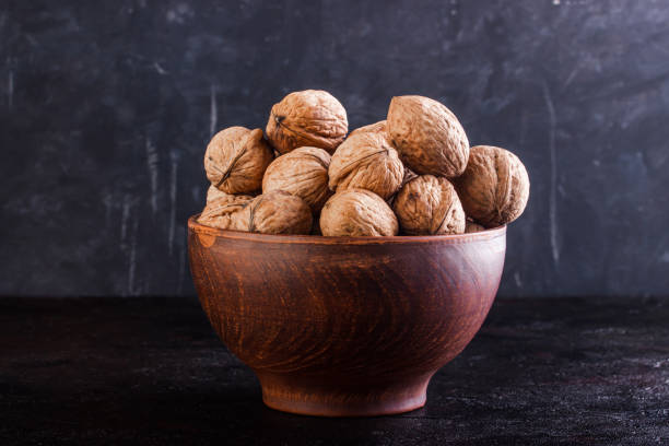 istock Walnut in pottery against a dark background 1253515348