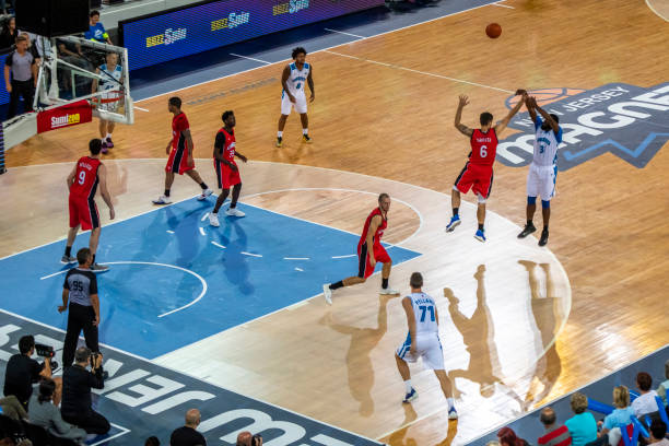 istock Basketball players tackling for ball 1253516491