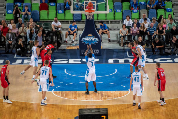 istock Basketball player slam dunking ball 1253516494