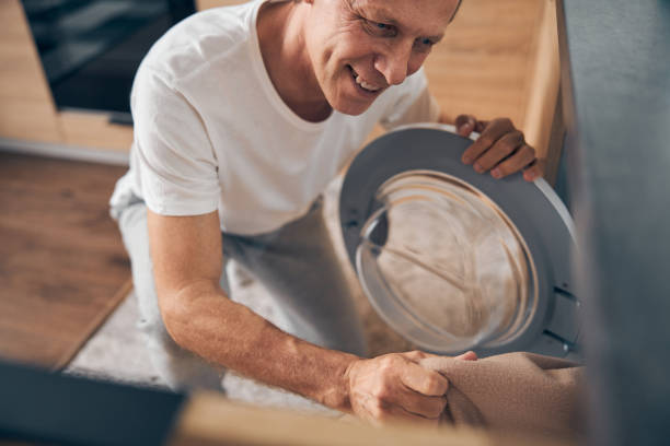 istock Focused photo on cheerful man looking at washer 1253516717