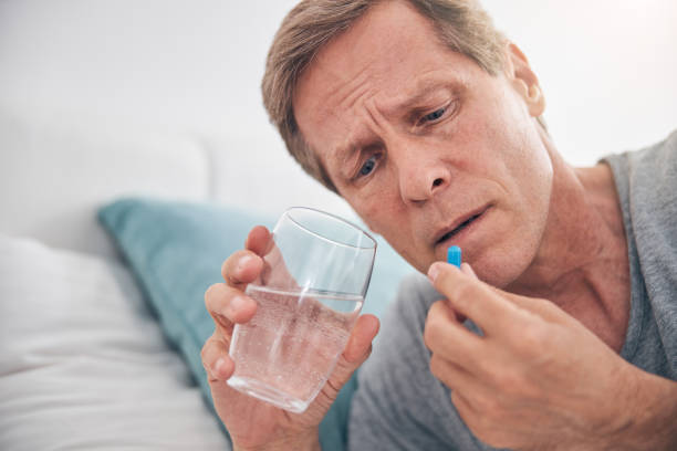 istock Concentrated male person staring at blue pill 1253516779