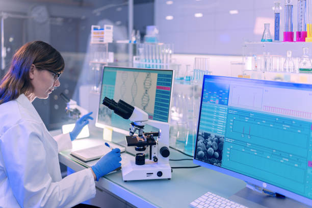 istock Female scientists typing on computer keyboard. Monitors with DNA study in background 1253517122