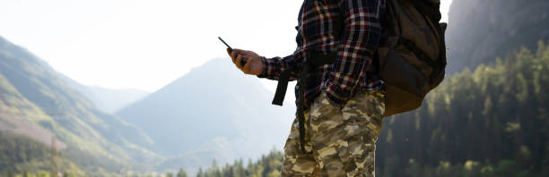 istock men with backpack holding smart phone in the mountains 1253517123