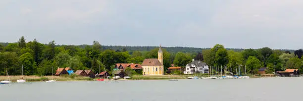 Ammersee, Bavaria / Germany - June 3, 2020: Panorama view on the lakeshore of Lake Ammersee with catholic church St. Alban.