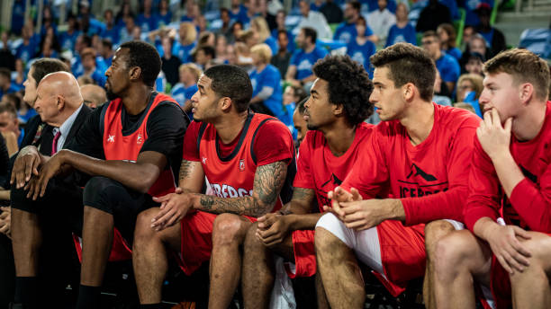 istock Basketball players and coach sitting on bench 1253517898