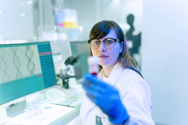 istock Female scientists typing on computer keyboard. Monitors with DNA study in background 1253518009