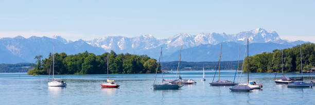 Lake Starnberg with Roseninsel and anchoring sailboats Starnberger See, Bavaria / Germany - June 12, 2020: Panorama of Lake Starnberg with Roseninsel (rose island) and anchoring sailboats. Alps with Zugspitze at the horizon. bavarian alps photos stock pictures, royalty-free photos & images