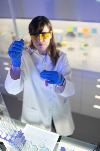 istock Working with medical samples. Woman using pipette. Looking through glassware 1253518068