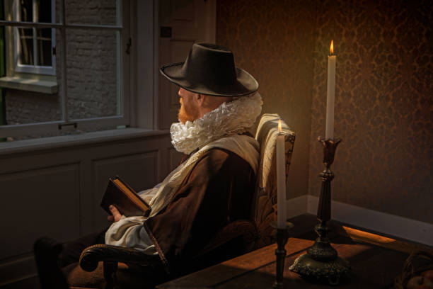 istock Redhead traditional dutch man reading a book by candlelight 1253518096
