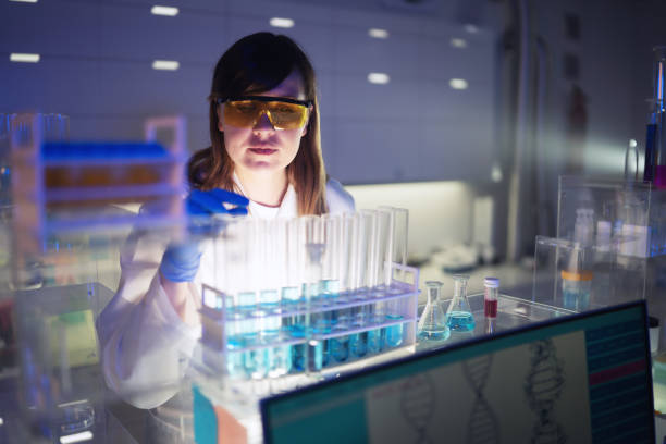 istock Working with medical samples. Woman using pipette. Looking through glassware 1253518115