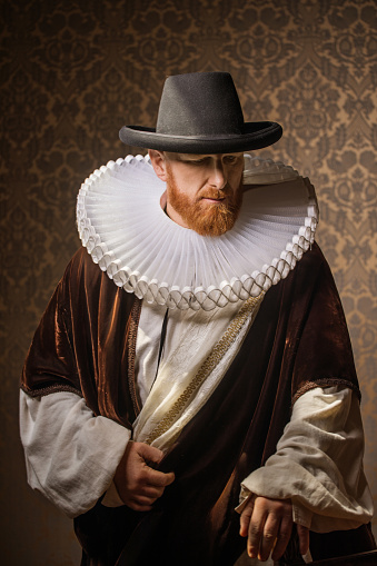 medieval queen in red dress with white collar and crown on dark gray background.