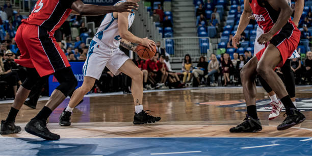 istock Basketball players tackling for ball 1253518435