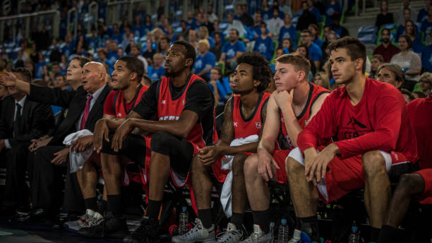 istock Basketball players and coach sitting on bench 1253518436