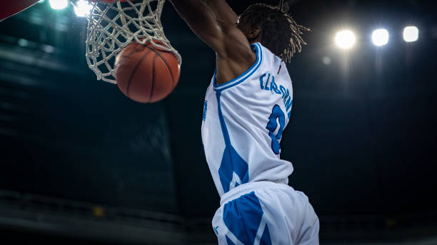 istock Basketball player hanging from hoop 1253518441