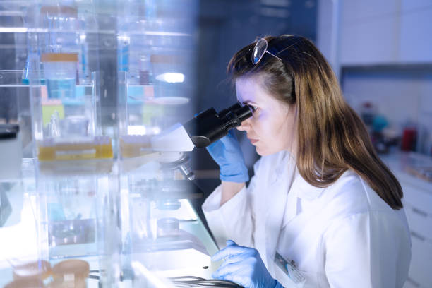 istock Working with medical samples. Woman using microscope. Futuristi laboratory 1253518525