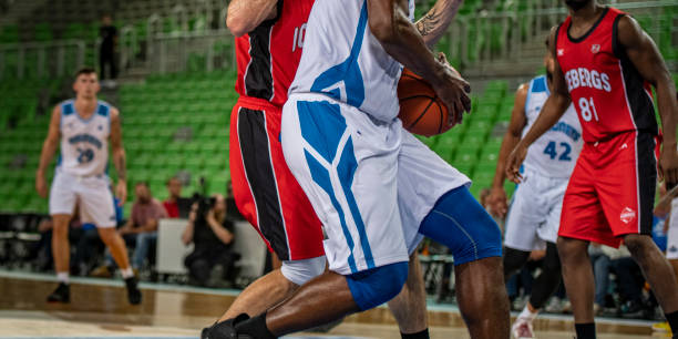istock Basketball players tackling for ball 1253519393