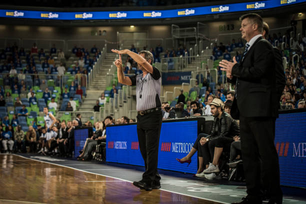 Coach and referee watching basketball match