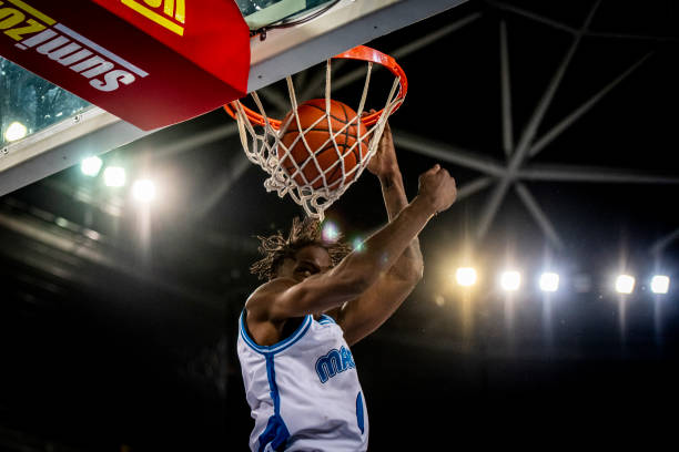 istock Basketball player hanging from hoop 1253521048