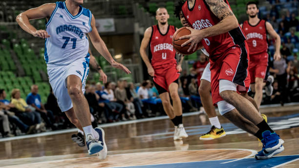 istock Basketball players tackling for ball 1253521050