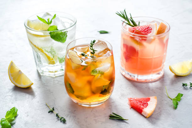Summer refreshing drinks with ice. Summer refreshing fruit drinks with ice on a grey background. refreshment stock pictures, royalty-free photos & images