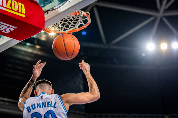 istock Basketball player slam dunking ball 1253521449