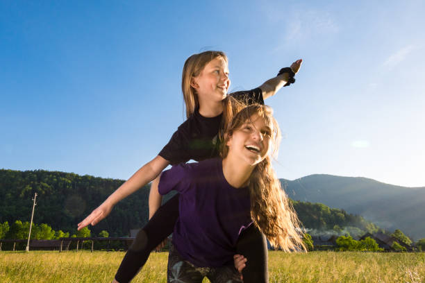 istock Two girls are playing on meadow - freedom concept 1253521705