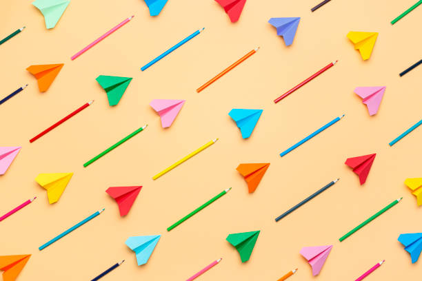 Back to school concept. Colorful pencils and paper airplanes pattern
