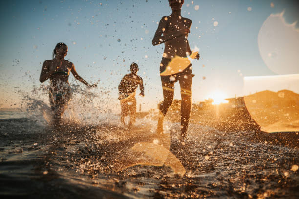 istock Brothers and sister running on beach 1253523658