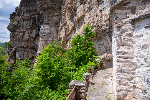 Young man sitting on top of cliff.