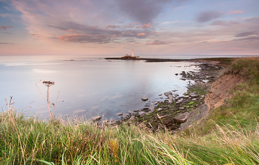 St Mary's Lighthouse and bay from the clifftops at Whitley Bay on the North East coast of England, on a pretty summer's evening at sunset.