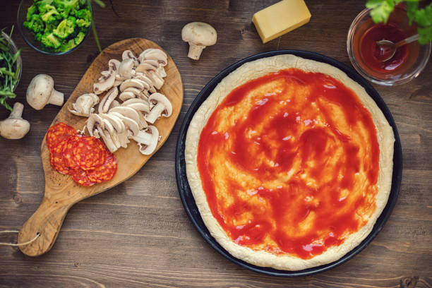 preparare la pizza fresca fatta in casa - tomato sauce domestic kitchen meat cheese foto e immagini stock