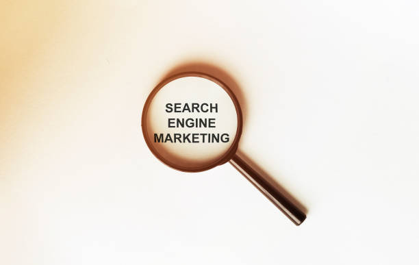 istock SEARCH ENGINE MARKETING on a sheet under a magnifying glass 1253529236